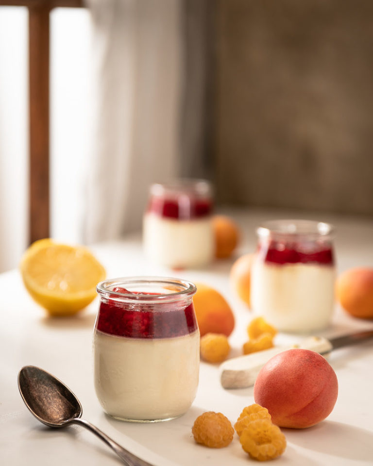 Panna Cotta by a window with apricot, raspberry lemon coulis