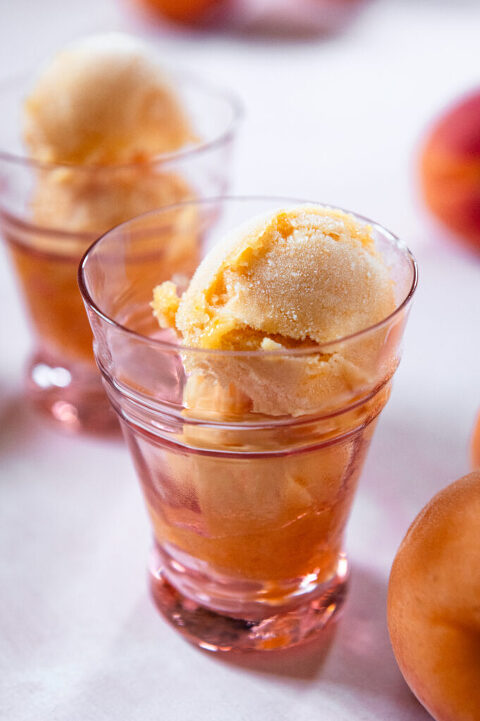 apricot peach sorbet in pink glasses on a pink surface