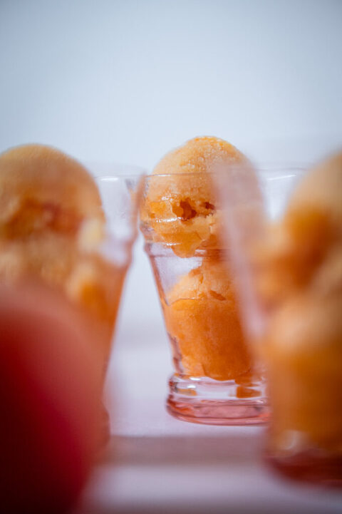 apricot peach sorbet in pink glasses on a pink surface