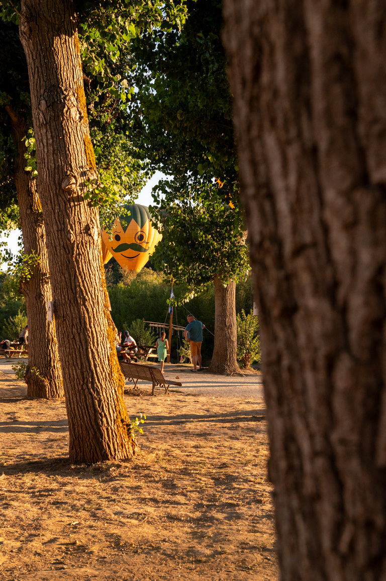 Montgolfières du Perigord hot air balloons between the trees in the Dordogne River at La Roque Gageac