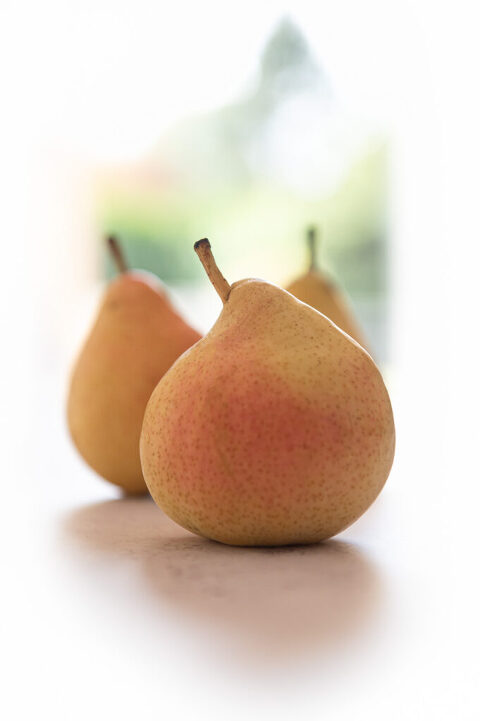 yellow pears backlit on a counter