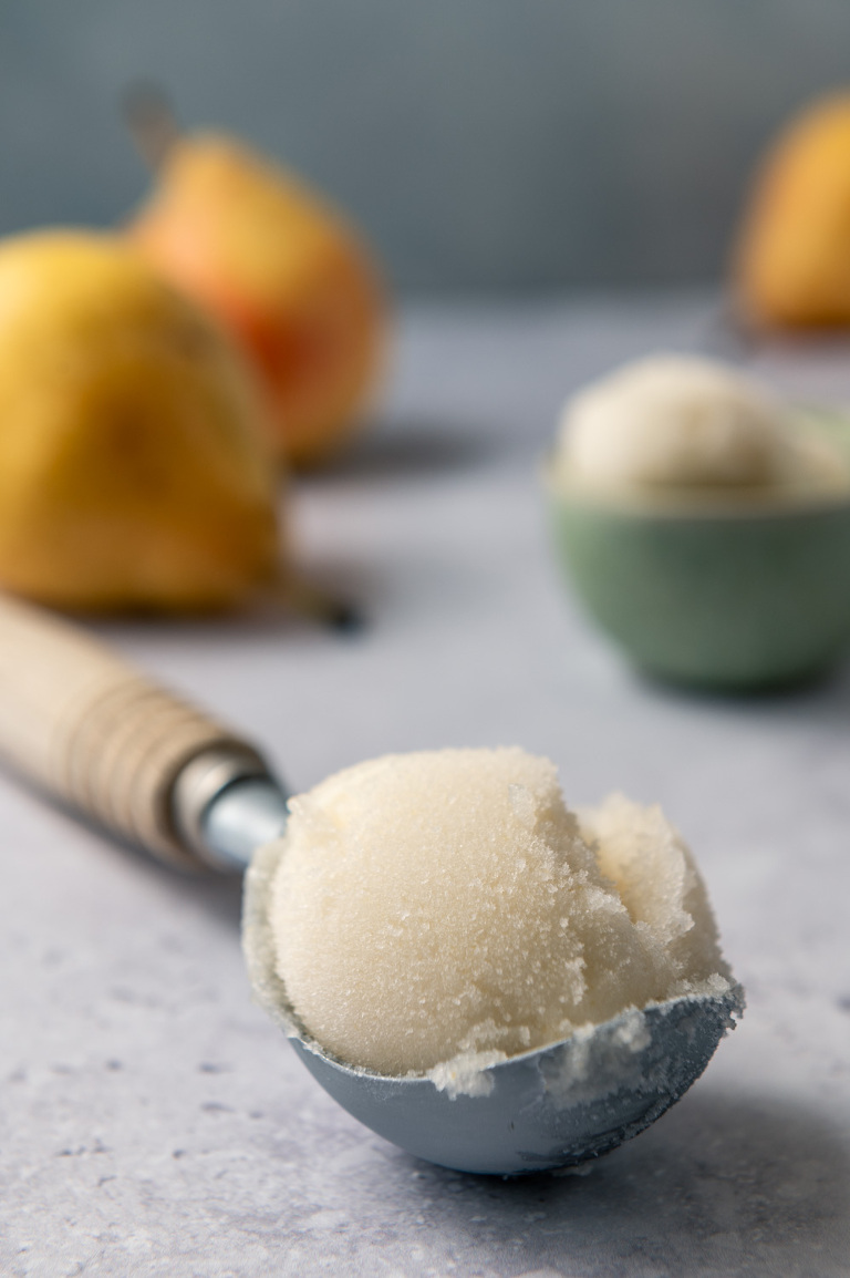 scoop of poached pear sorbet on a countertop
